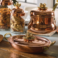 Hammered copper 10" covered oval gratin, tin-lined by hand over fire, with bronze handles. Shown with matching tea kettle and Lotus glass jars from the Glamstore Historia collection