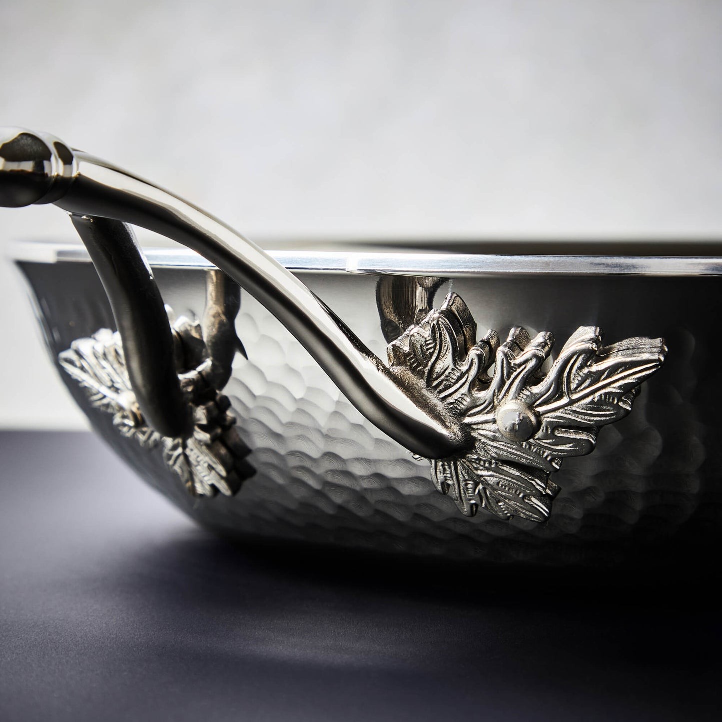 Details of the Opus Prima hammered clad stainless steel pan with decorated silver-plated
