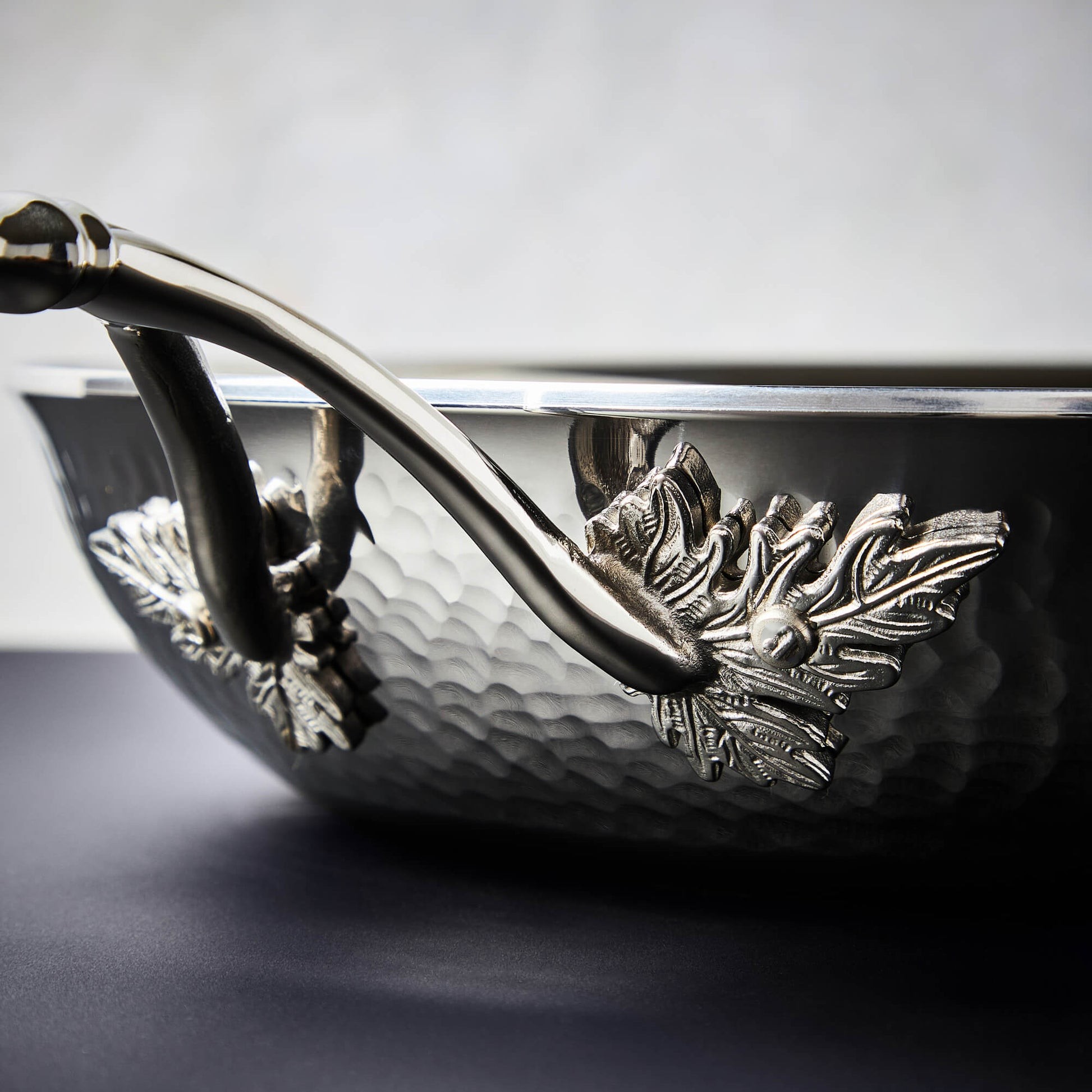 Details of the Opus Prima hammered clad stainless steel pan with decorated silver-plated