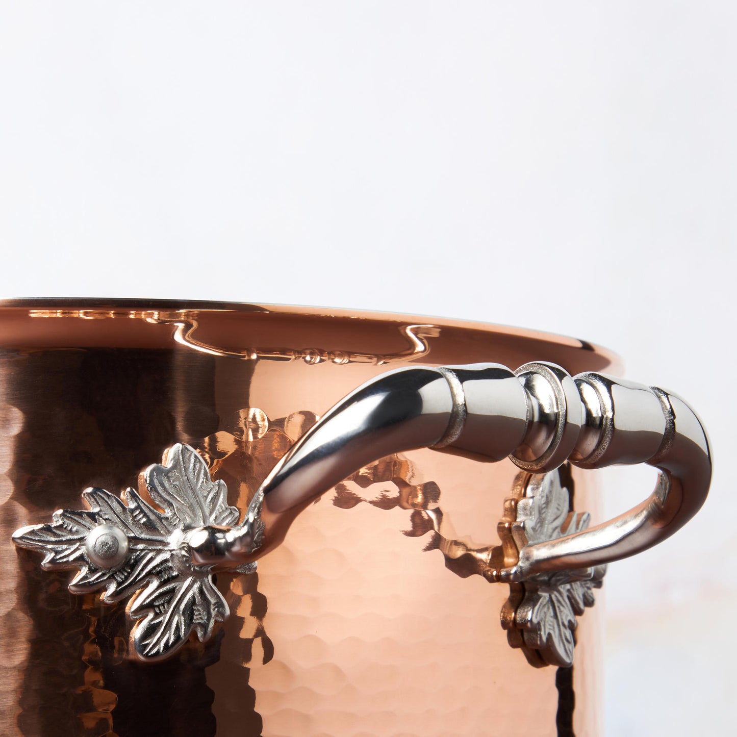 Beautiful stainless steel helper handle decorated with delicate leaves on Opus Cupra cookware
