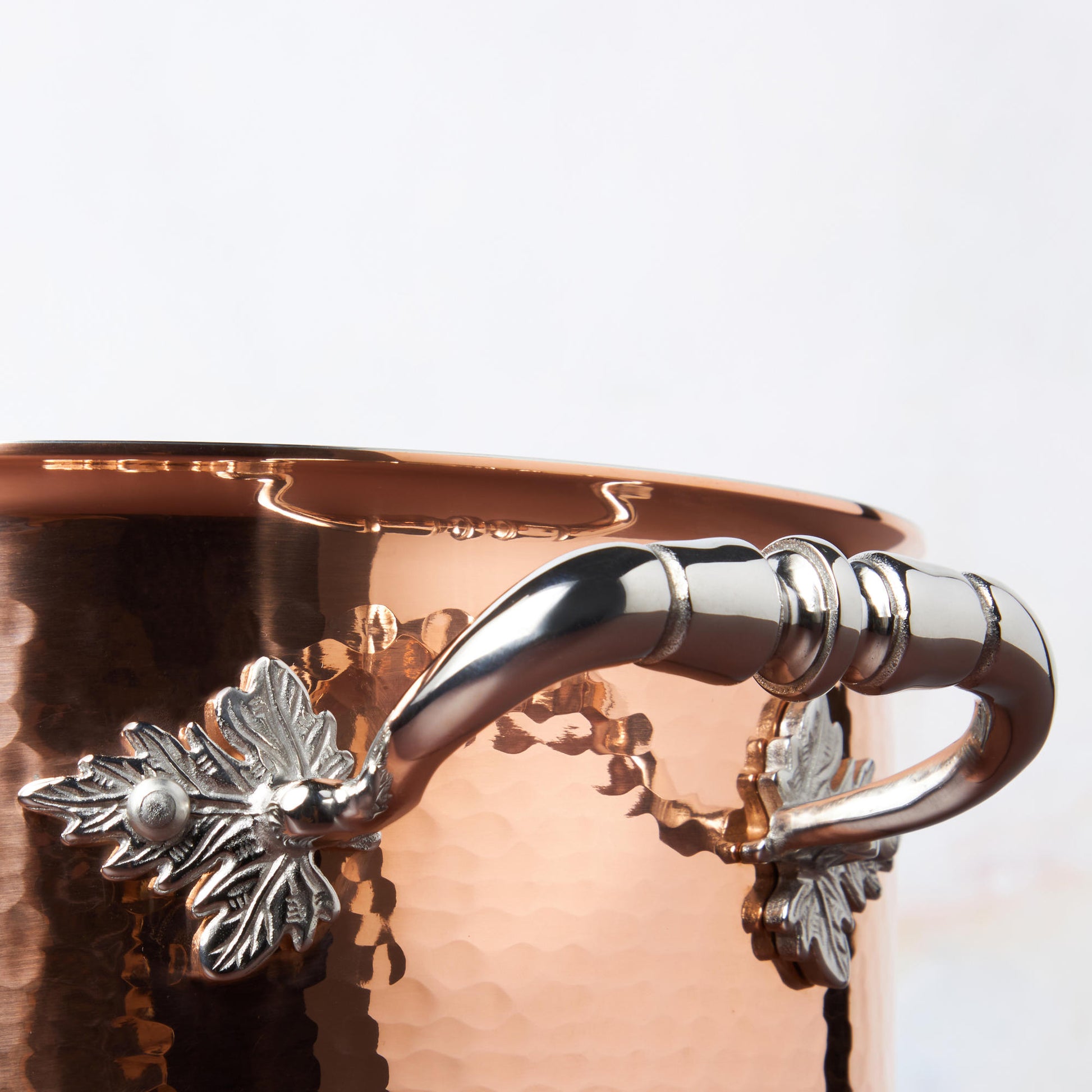 Beautiful stainless steel helper handle decorated with delicate leaves on Opus Cupra cookware