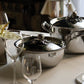 Opus Prima hammered clad stainless steel chef pan and stockpot with decorated silver-plated lid knob finial  on a classic tablesetting