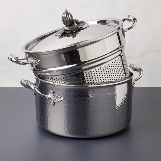 Opus Prima hammered clad stainless steel stockpot with decorated silver-plated lid knob finial  photographed with the matching pasta insert