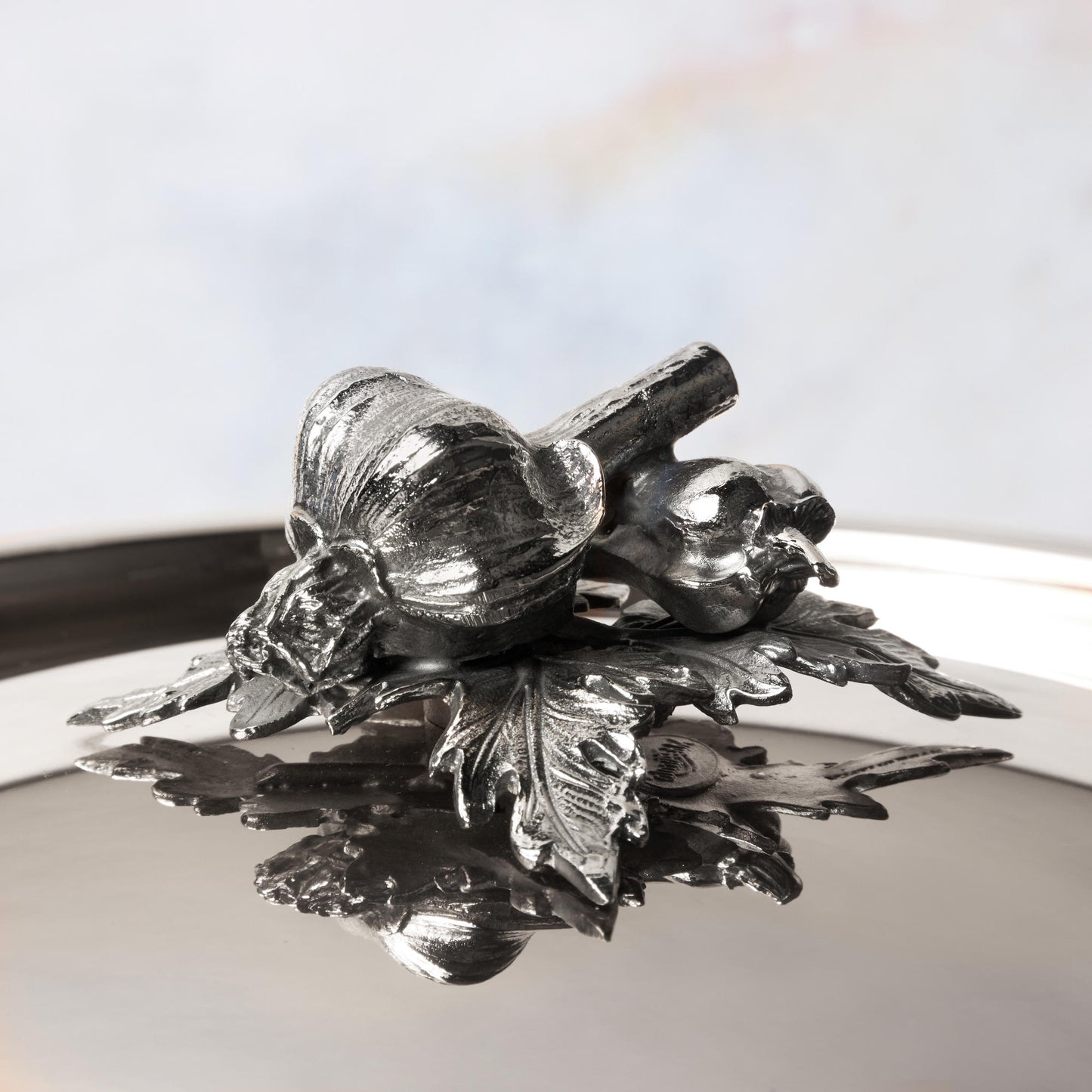 Decorated knob finial representing garlic and pepper, cast in solid bronze and silver plated, on Opus Prima stainless steel lid