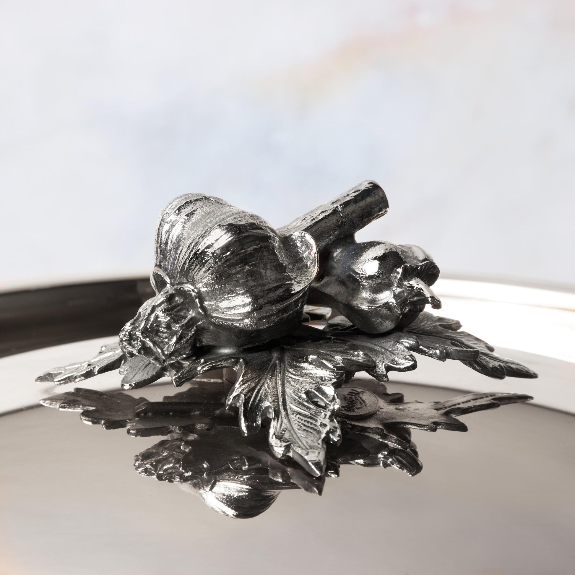 Decorated knob finial representing garlic and pepper, cast in solid bronze and silver plated, on Opus Prima stainless steel lid