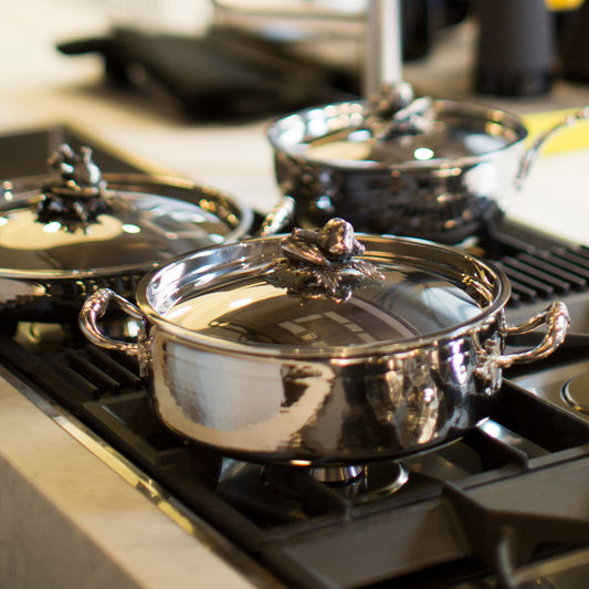 Opus Prima hammered clad stainless steel braiser with decorated silver-plated lid knob finial a modern kitchen setting