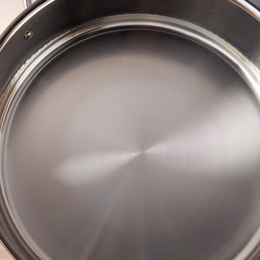 Sunray polished and hammered stainless steel lining in saucepan