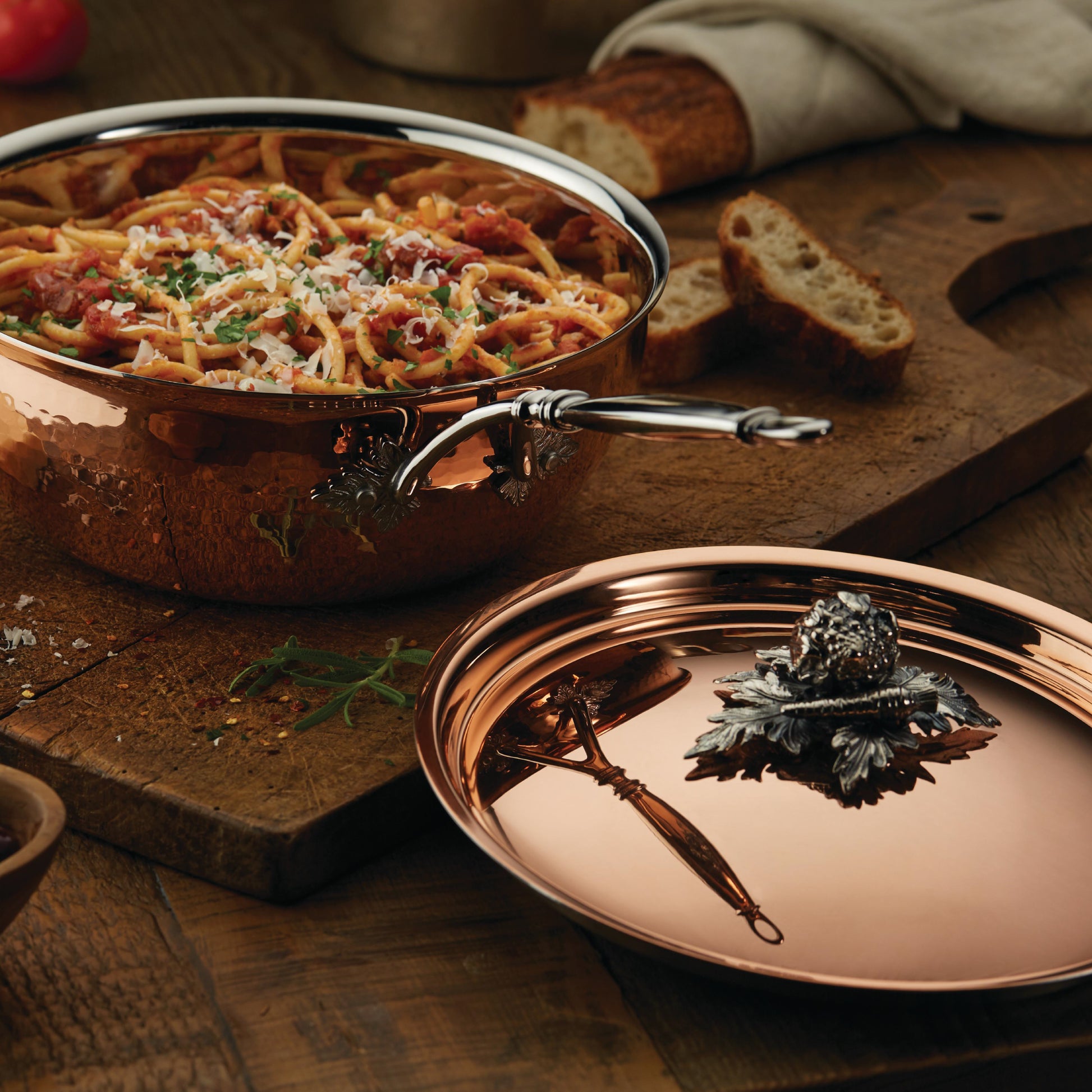 Opus Cupra hammered copper chef pan with stainless steel lining and decorated silver-plated lid knob finial  used to serve Italian spaghetti
