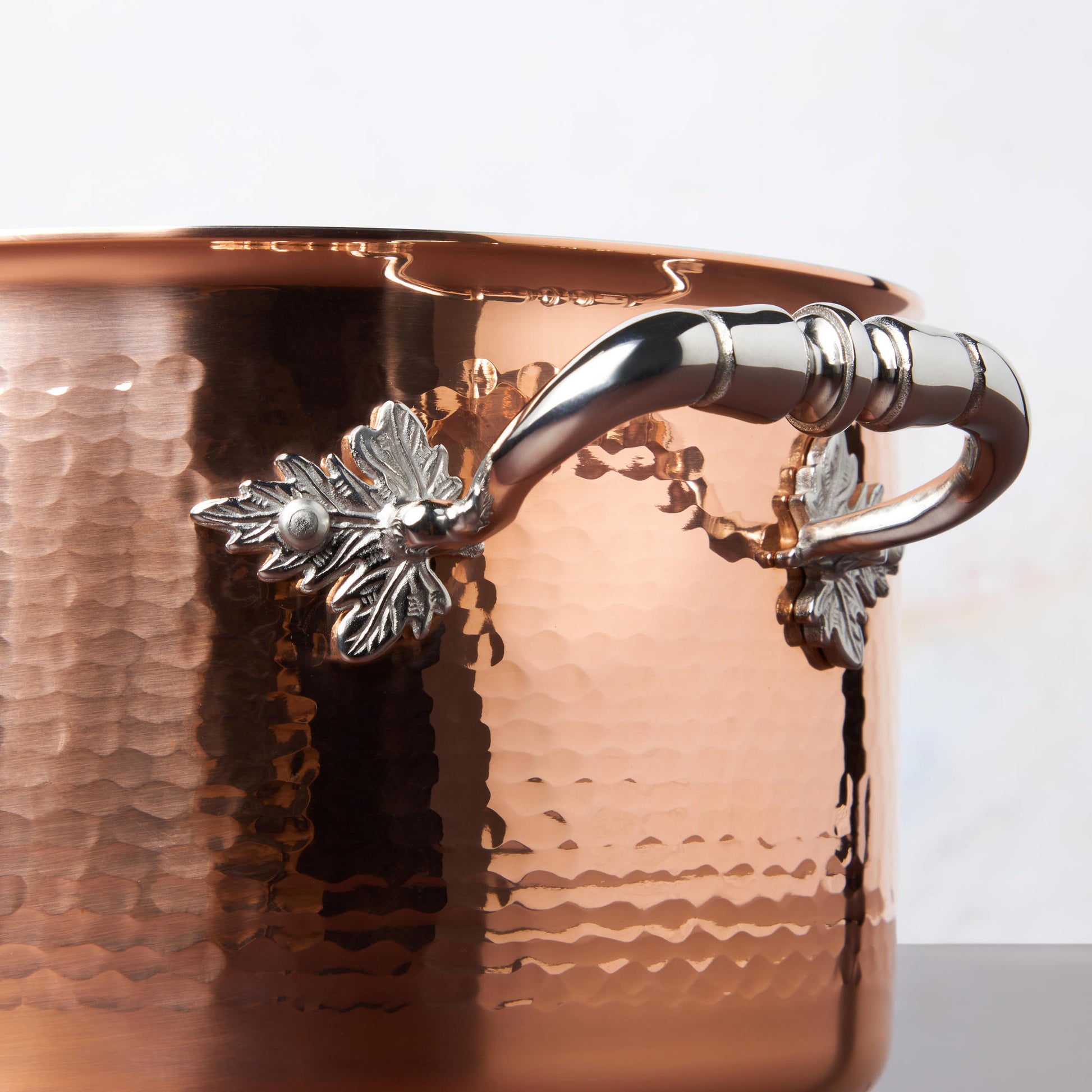 Beautiful stainless steel handle decorated with delicate leaves on Opus Cupra cookware
