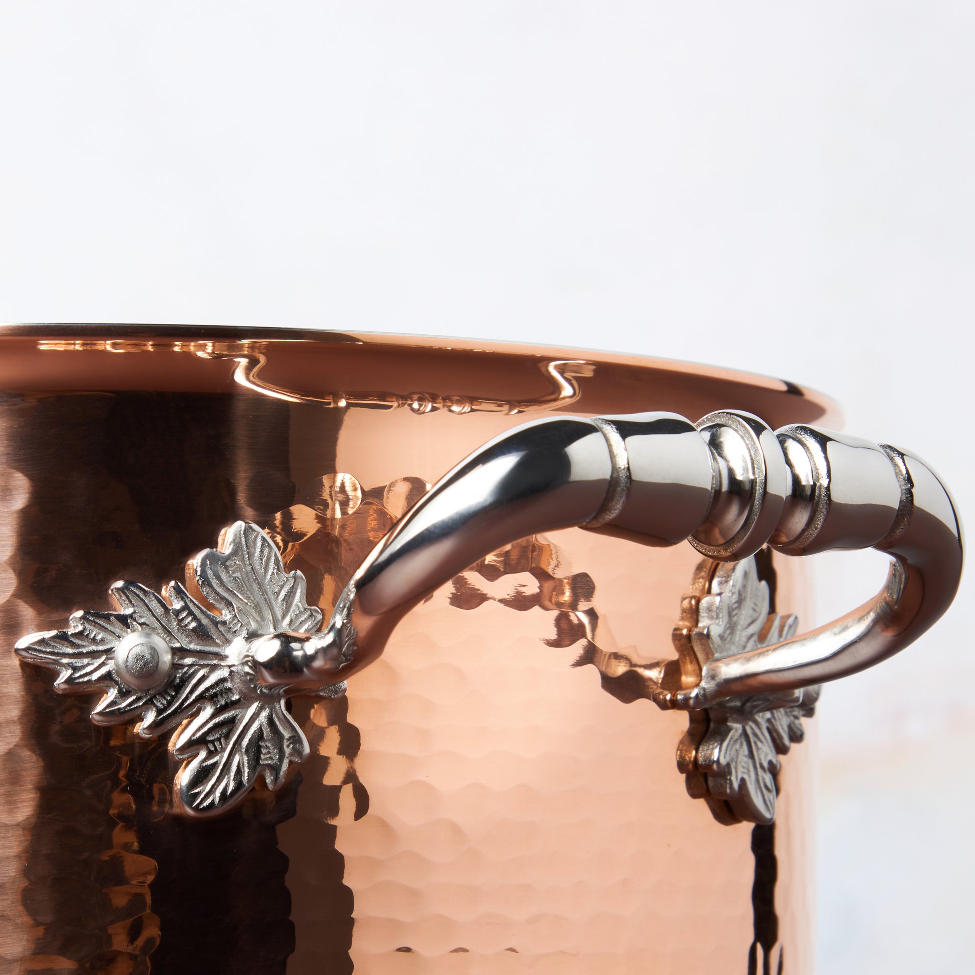 Beautiful stainless steel handle decorated with delicate leaves on Opus Cupra cookware