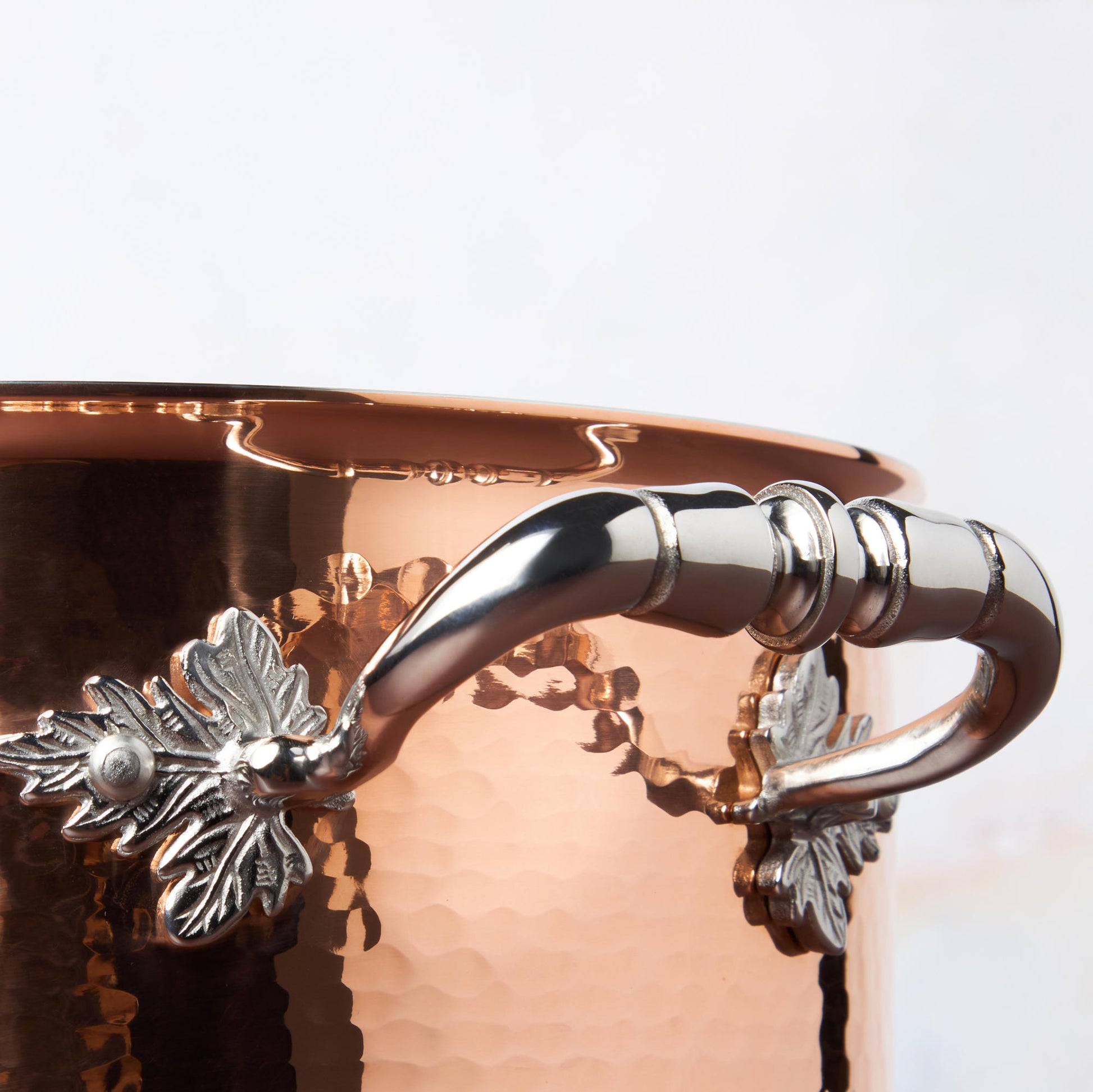 Beautiful stainless steel handle decorated with delicate leaves on Opus Cupra cookware