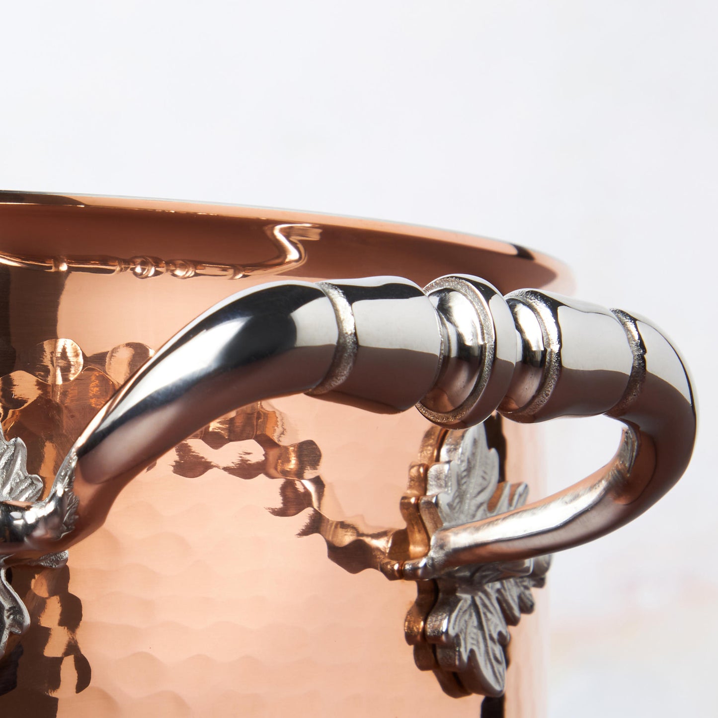 Beautiful stainless steel handle decorated with delicate leaves on Opus Cupra cookware