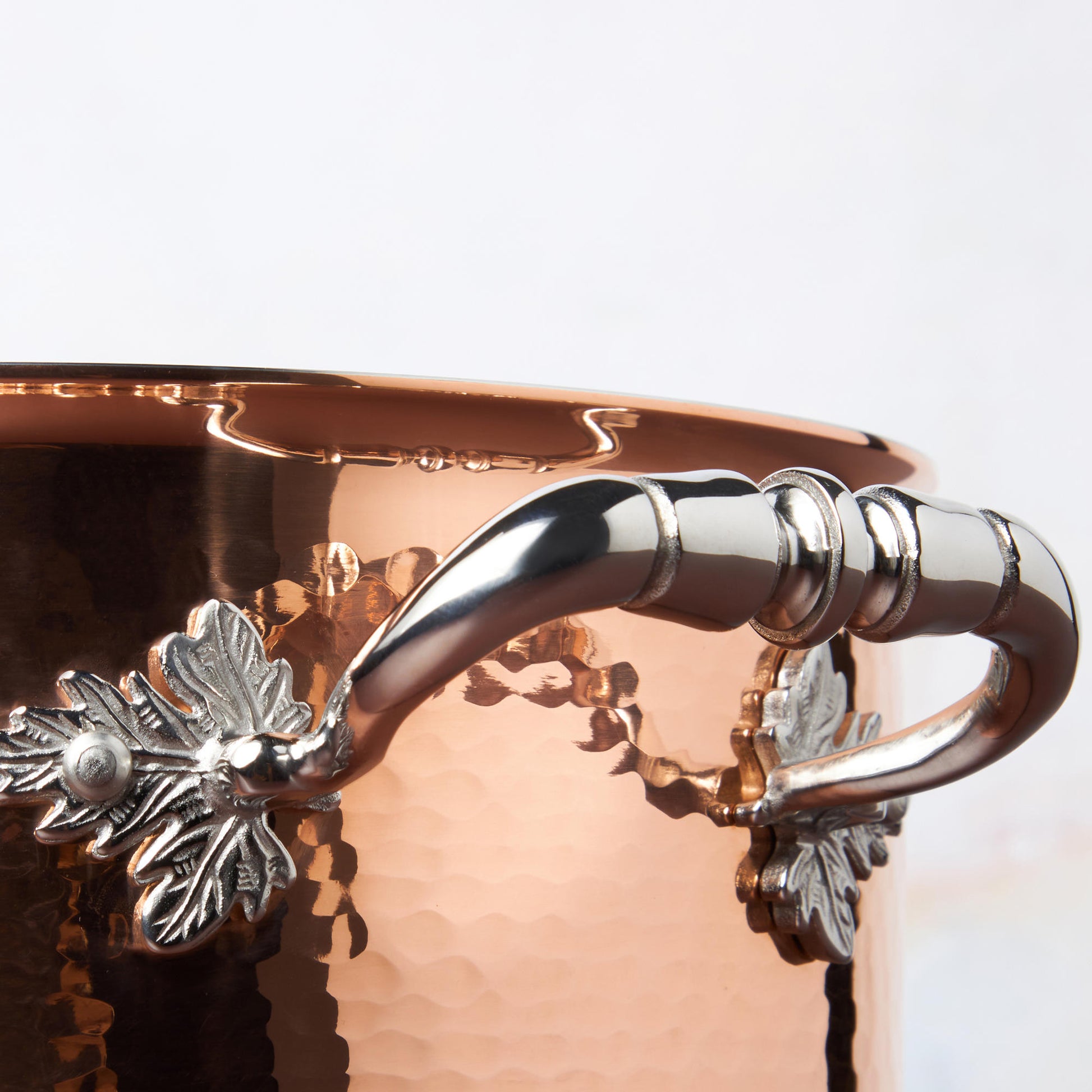 Beautiful stainless steel helper handle decorated with delicate leaves on Opus Cupra cookware