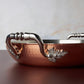 Beautiful stainless steel handle decorated with delicate leaves on Opus Cupra cookware