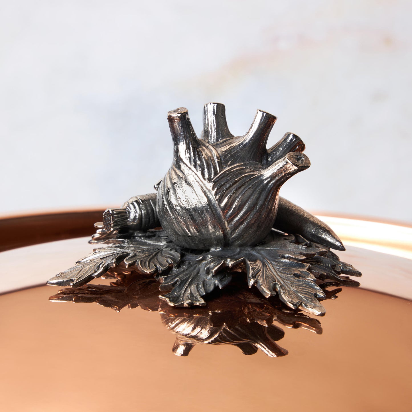Decorated knob finial representing fennel, carrot and bean, cast in solid bronze and silver plated, on Opus Cupra clad copper lid