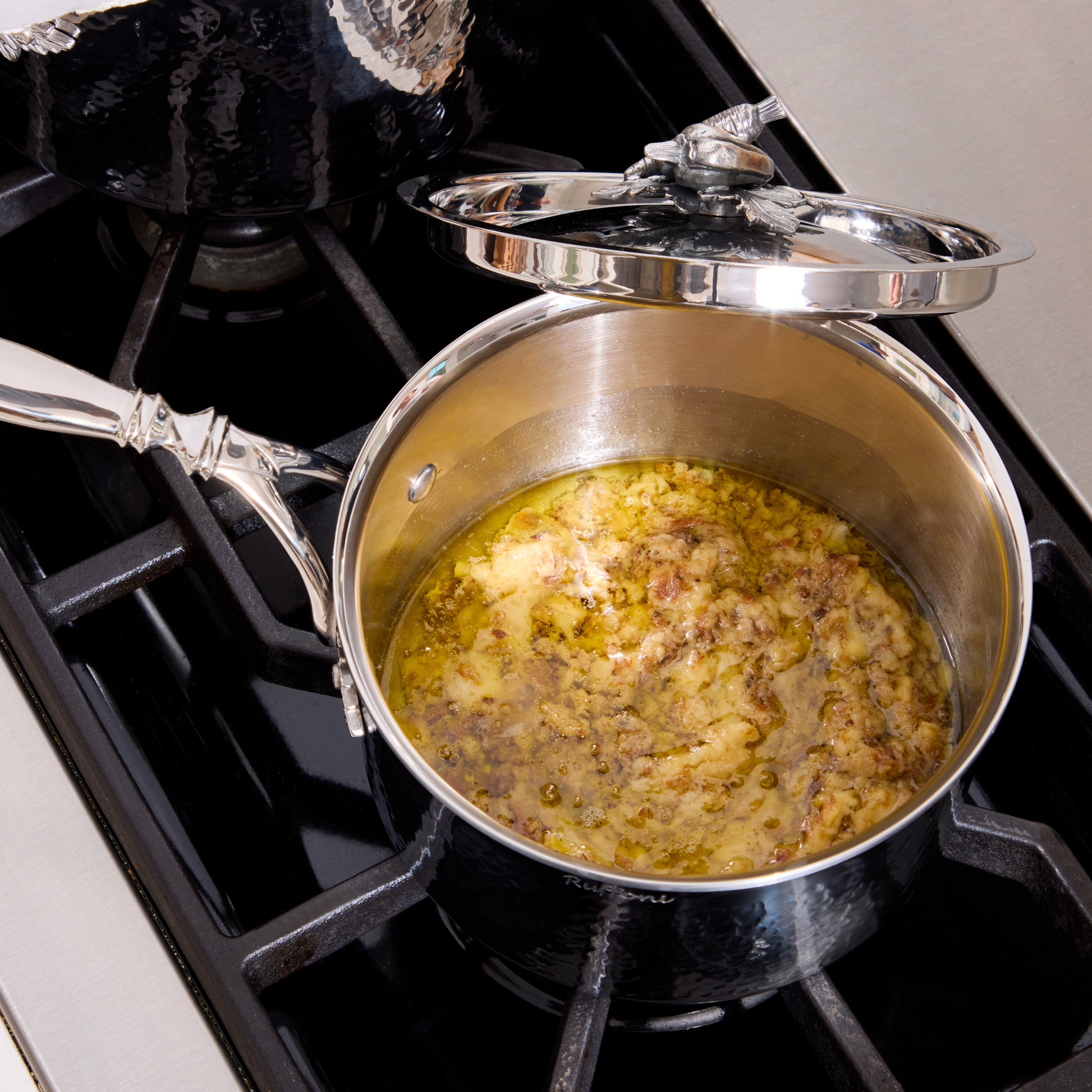Bagna cauda in an Opus Prima hammered clad stainless steel saucepan with decorated silver-plated lid knob finial.