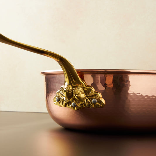 Beautiful bronze stick handle decorated with acorns on Historia cookware