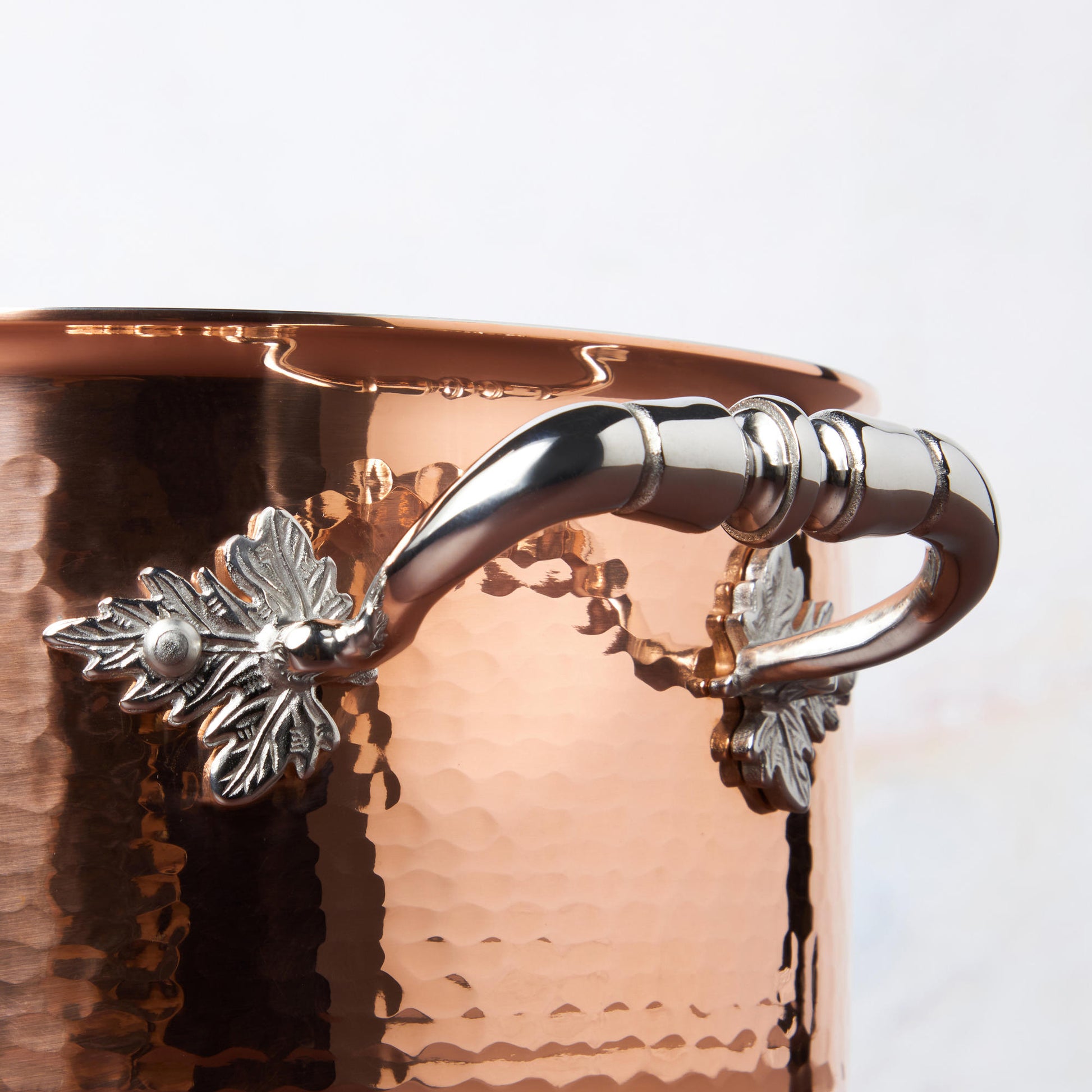 Beautiful stainless steel handle decorated with delicate leaves on Opus Cupra cookware