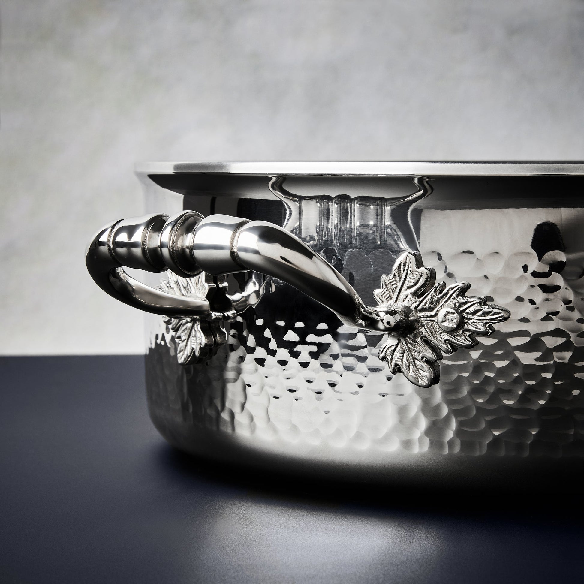Beautiful clad stainless steel handle decorated with delicate leaves on Opus Prima cookware